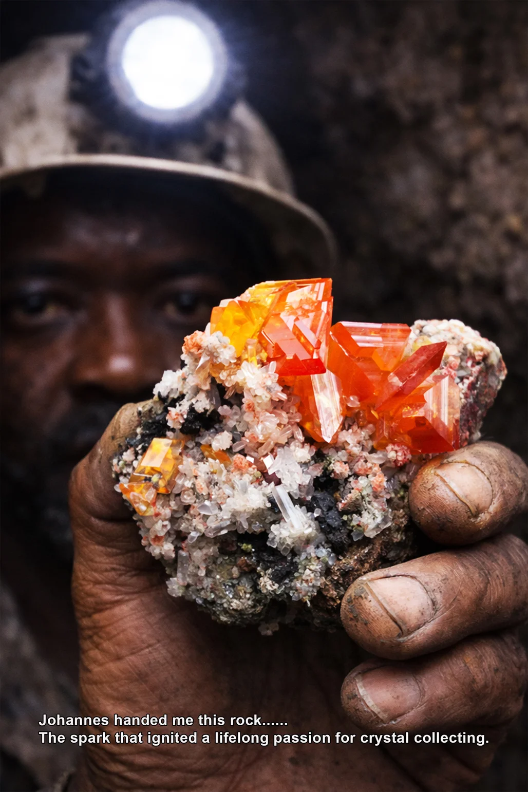 Miner with a rock containing crystals